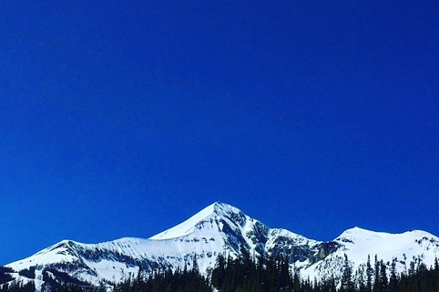 Snow capped mountains beneath a deep blue sky.